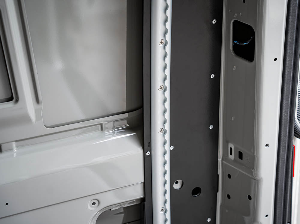 Close-up view of Driver's side of Sprinter Van Bed Bracket L-Track Kit installed on Sprinter Bed Brackets installed in Sprinter 144" camper van
