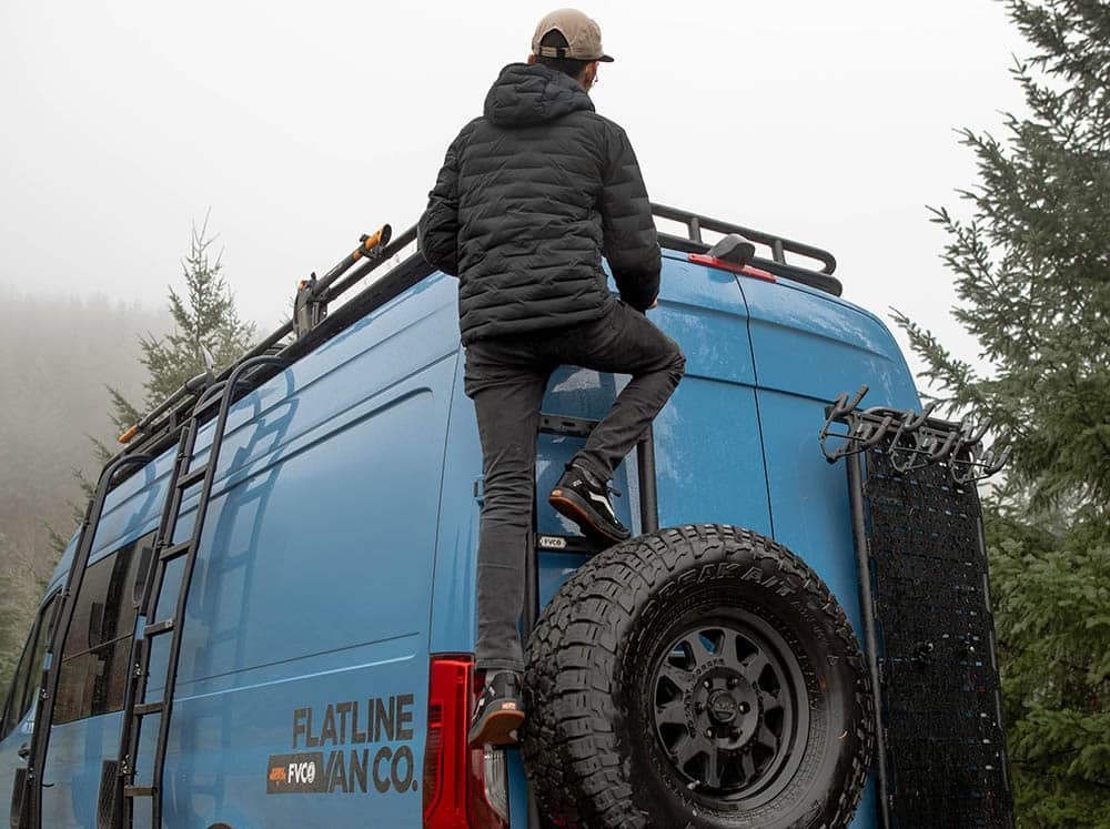 Person climbing rear ladder/tire carrier on Sprinter van