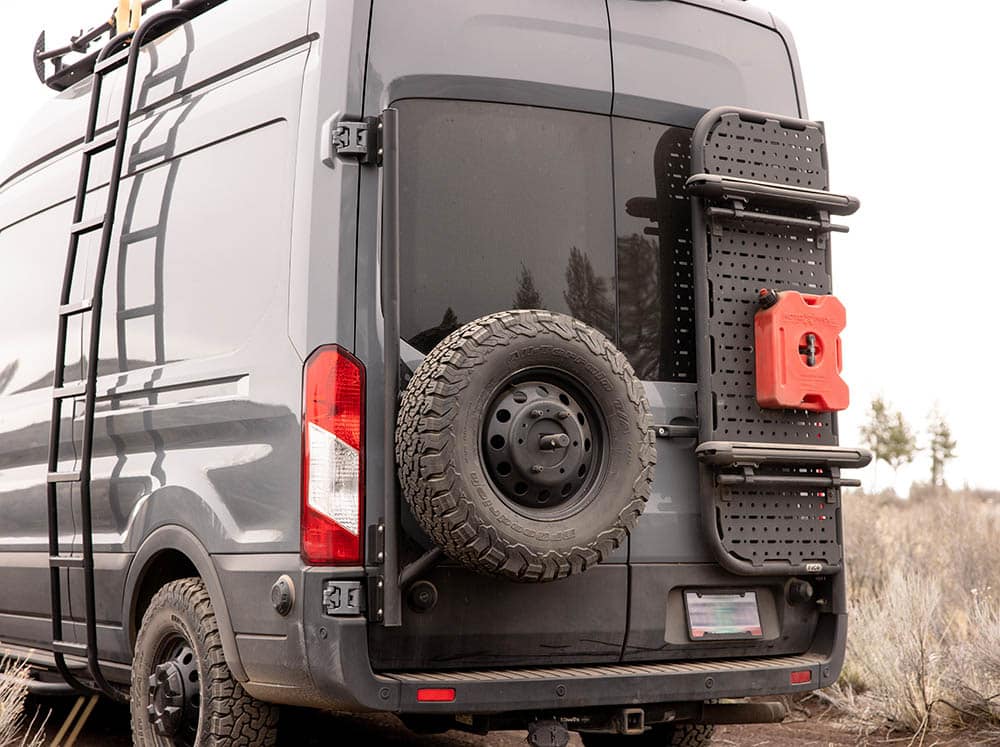 Transit van with rear tire carrier and rear door platform
