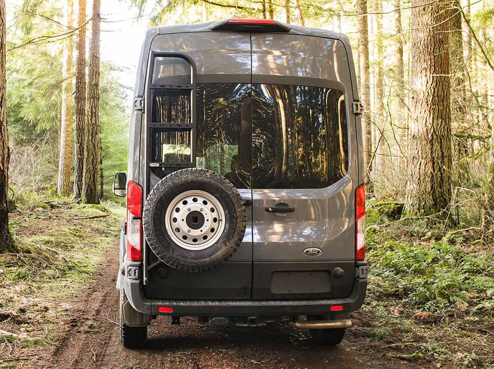 Transit rear tire carrier and ladder on van in the woods