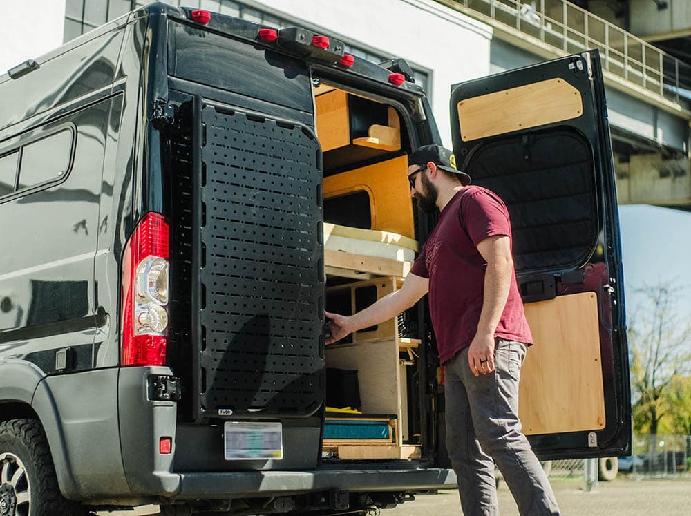 Man opening door with driver side Promaster Rear Door Platform installed