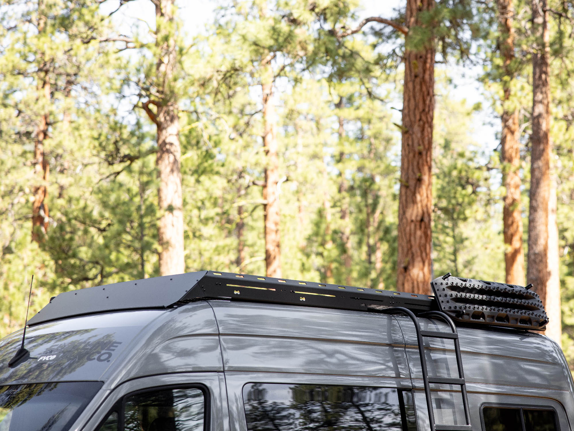 Sprinter Van Standard Roof Rack with normal fairing option installed on adventure van while camping in the woods