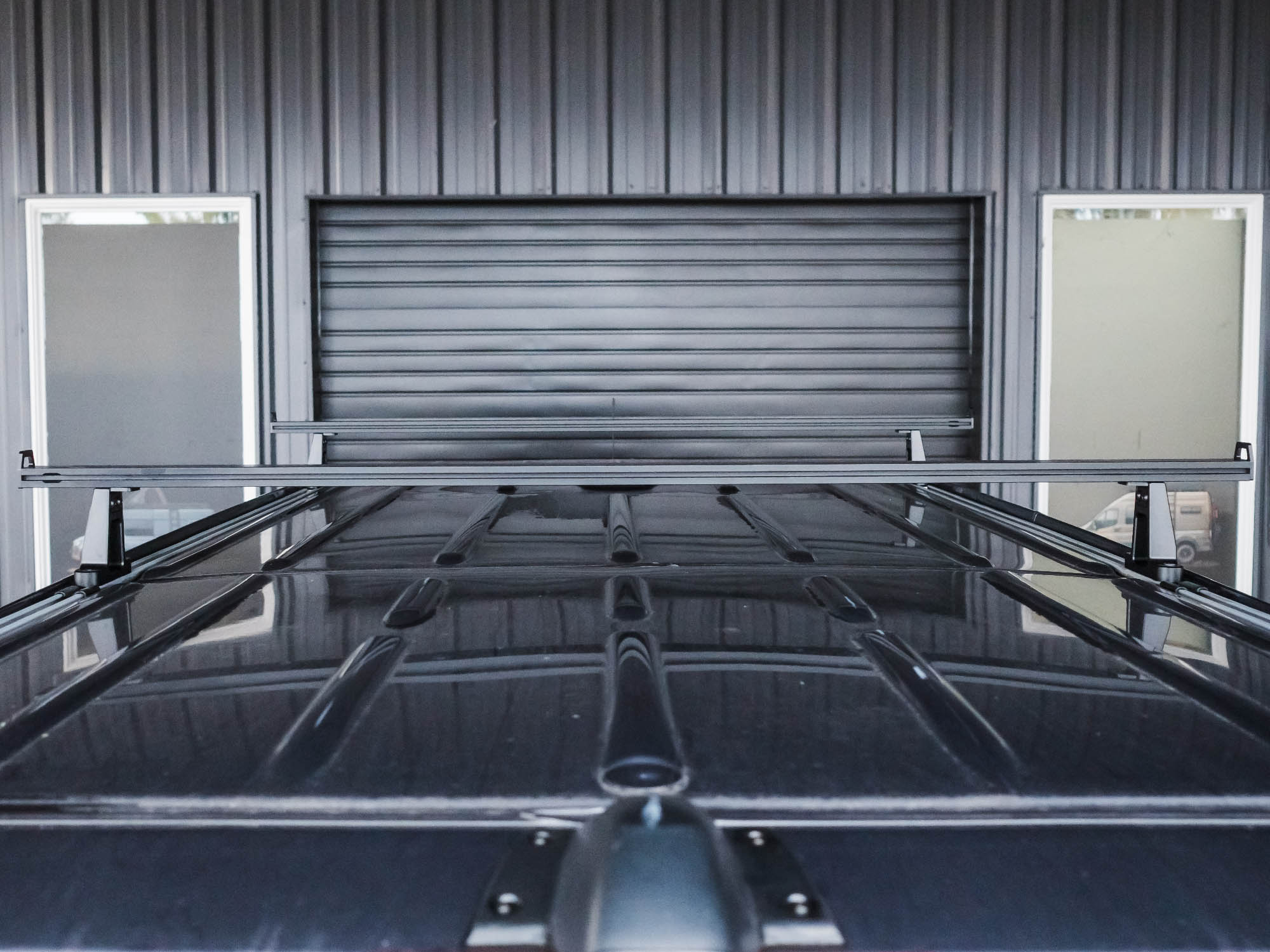 View of installed Sprinter Crossbar Roof Rack on a high roof van with the Standard 59.75" crossbar option