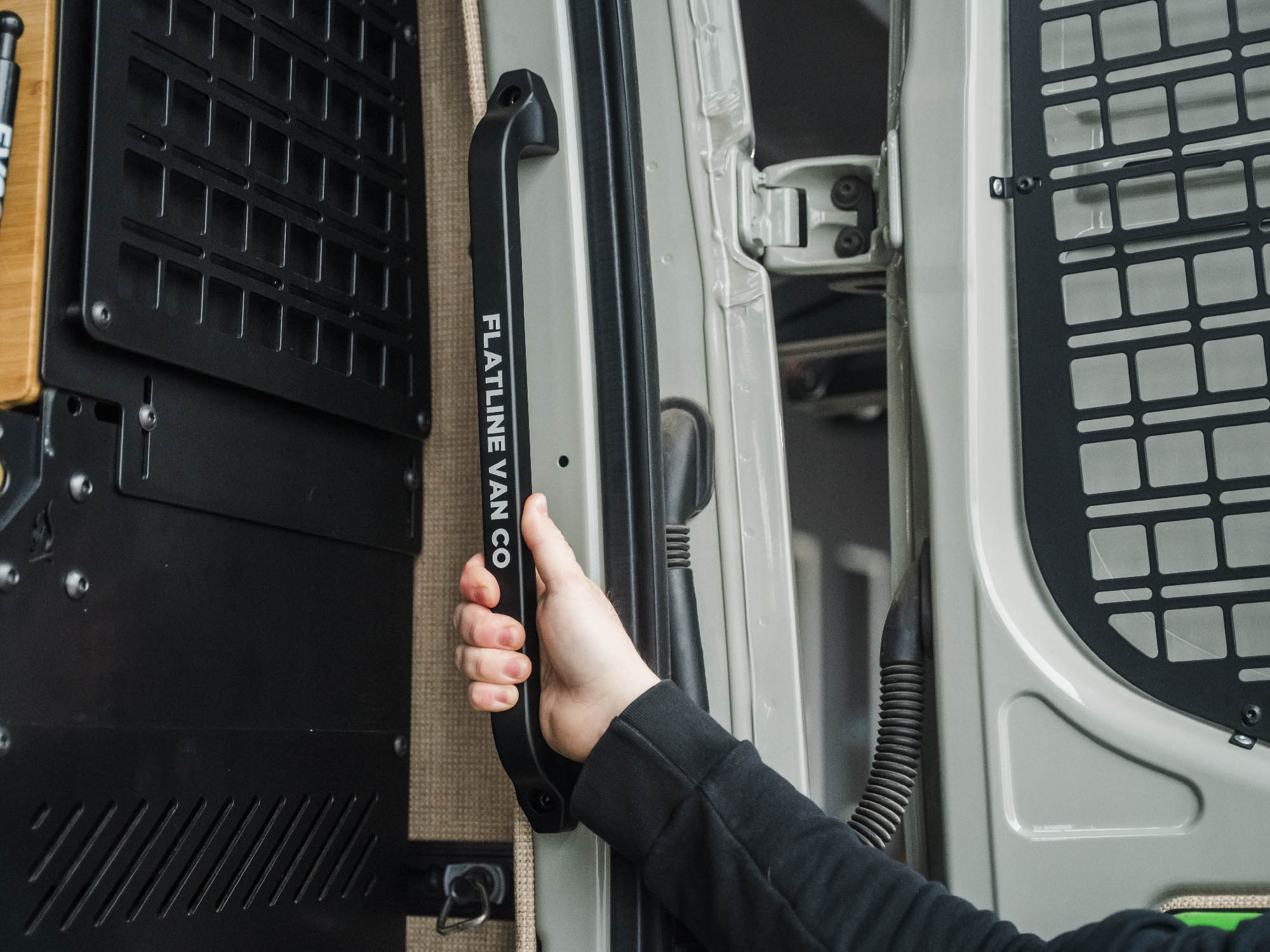 Person using the Sprinter Rear Door Grab Handle to step inside the van