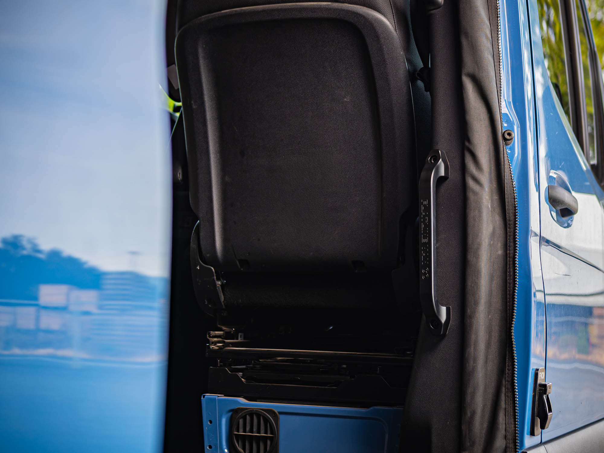 View of Sprinter Slider Grab Handle with black logo installed in blue Sprinter camper van