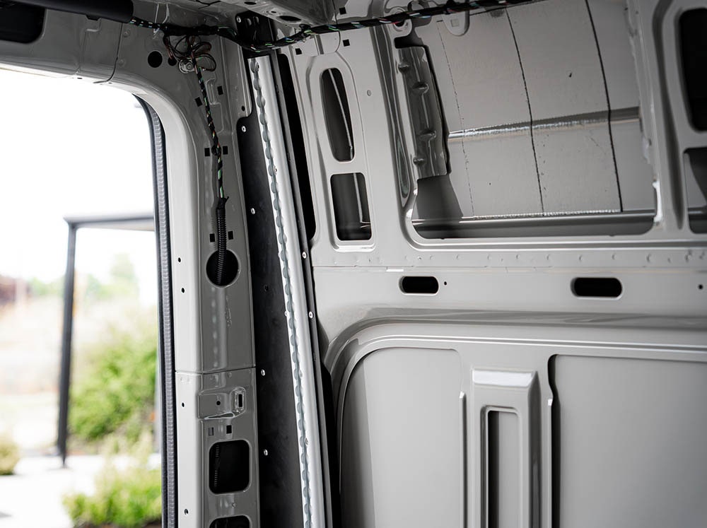 Close-up view of Driver's side of Sprinter Van Bed Bracket L-Track Kit installed on Sprinter Bed Brackets in 144" high roof Sprinter van