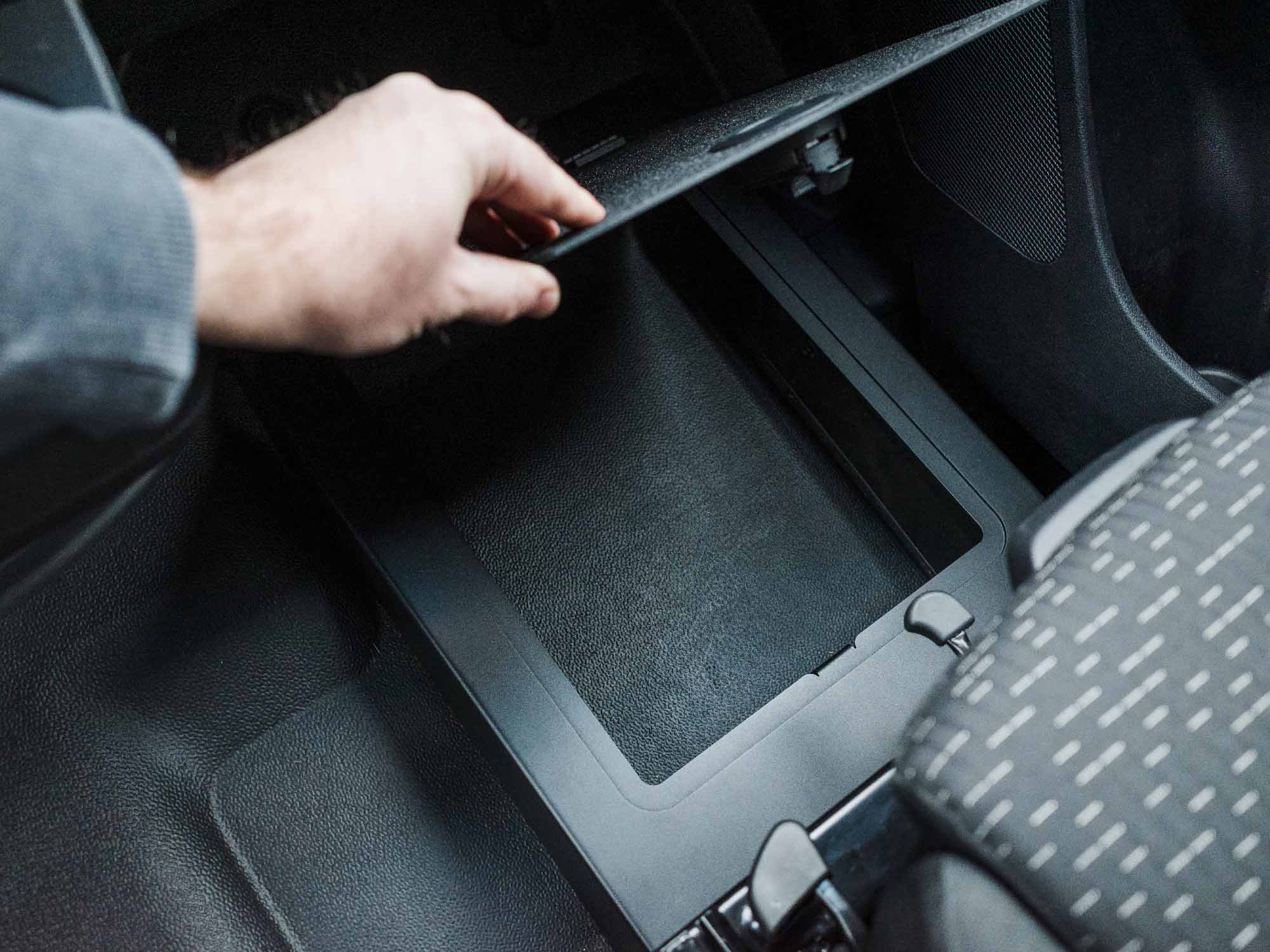 Person opening lid of Sprinter Passenger Floor Riser Compartment with storage and foot rest