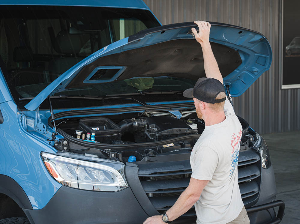 Person opening hood with FVC Sprinter Hood Strut Kit