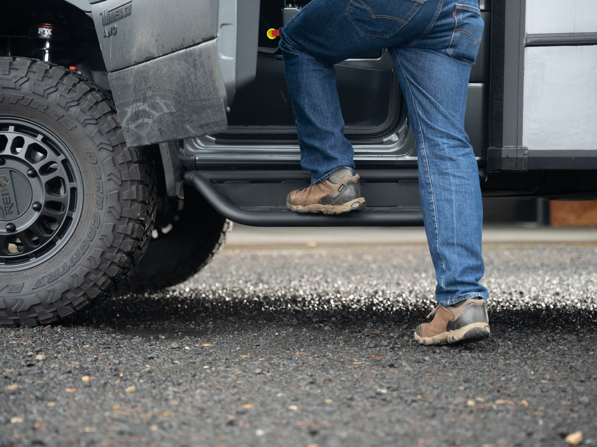 Person stepping into Winnebago Ekko Sprinter with Ekko Sprinter Side Steps installed