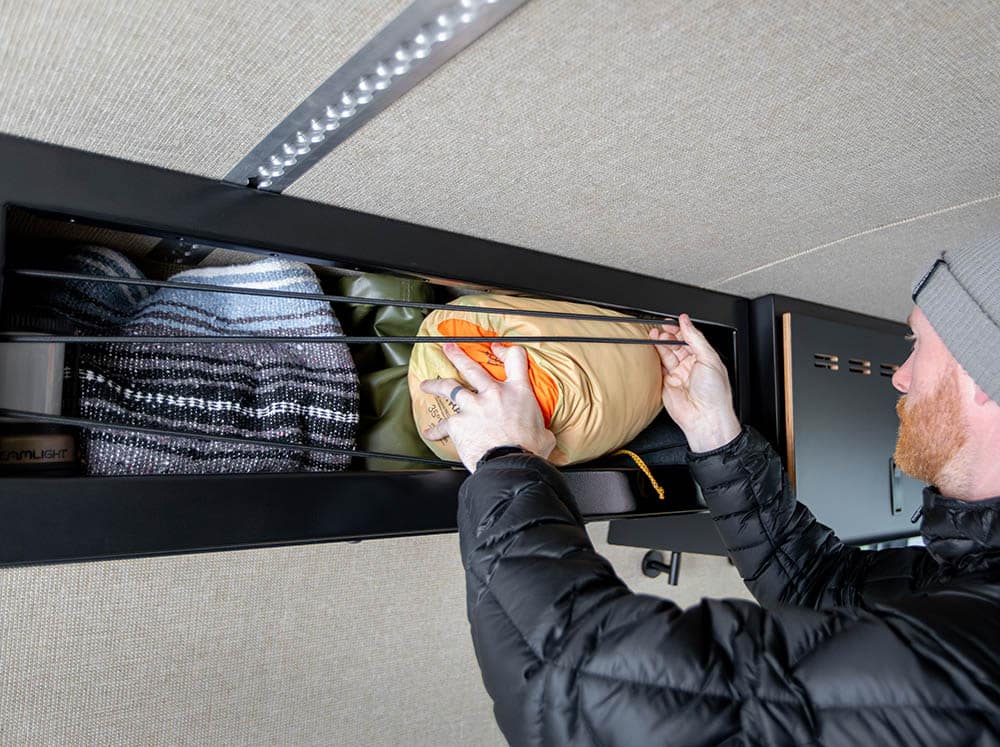 Person removing sleeping bag from Sprinter 36" open face upper cabinet