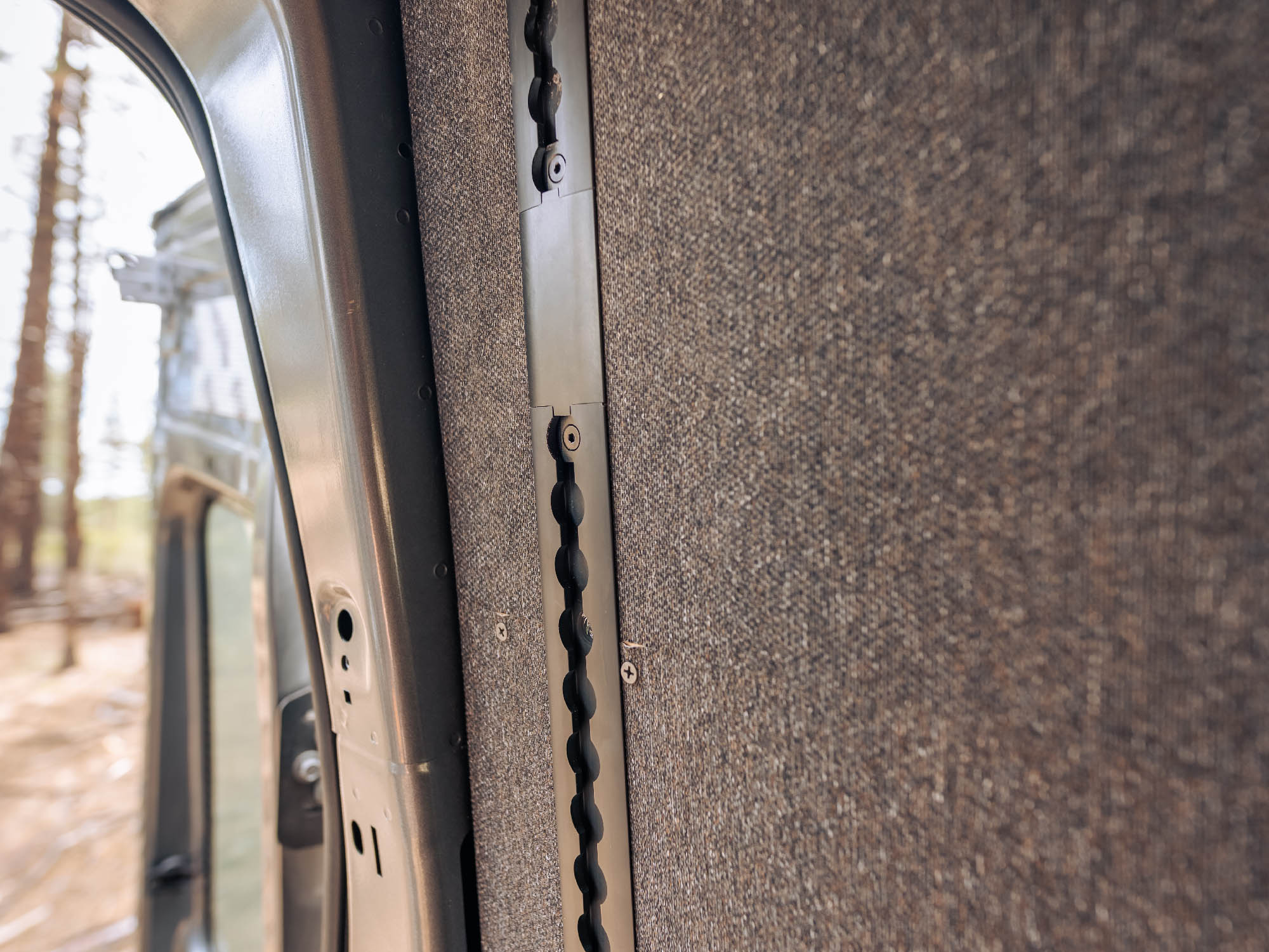 Close up view of Transit Bed Bracket Flush Mount L-Track installed, with integrated solid piece that goes over the electrical