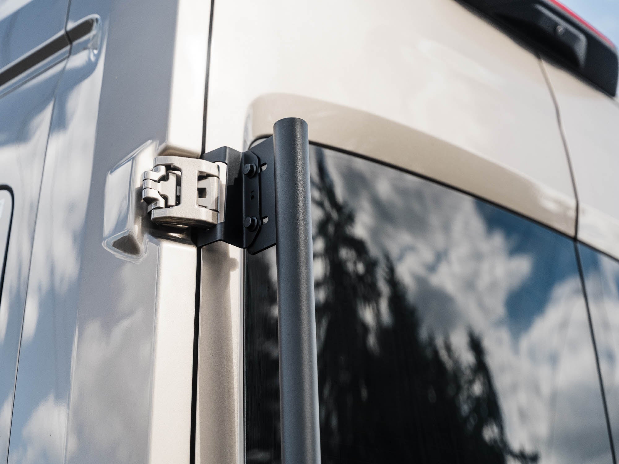 Detail view of Transit Tire Carrier mounted on driver door hinges
