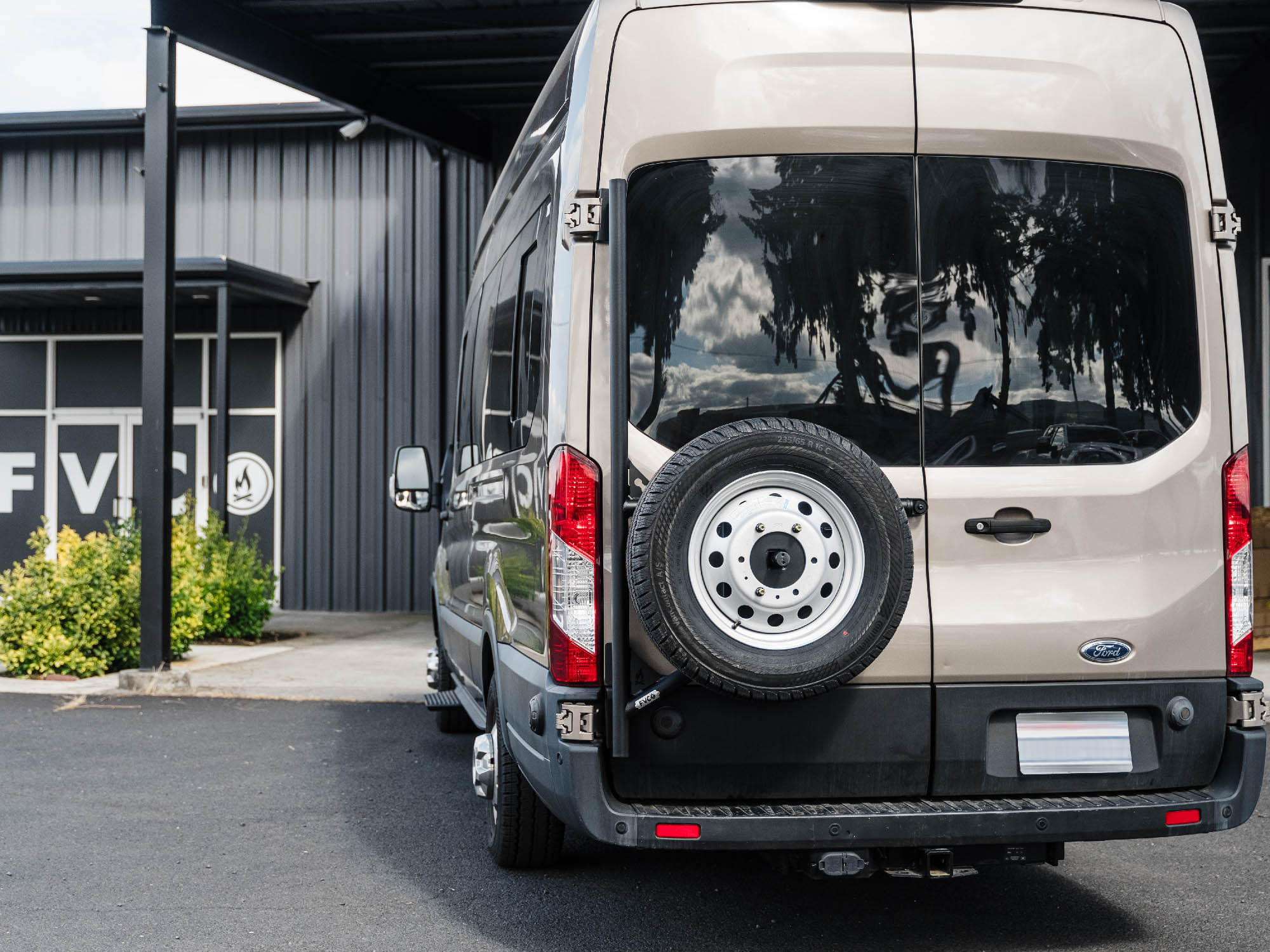 Transit Van Tire Carrier installed on camper van with stock tires