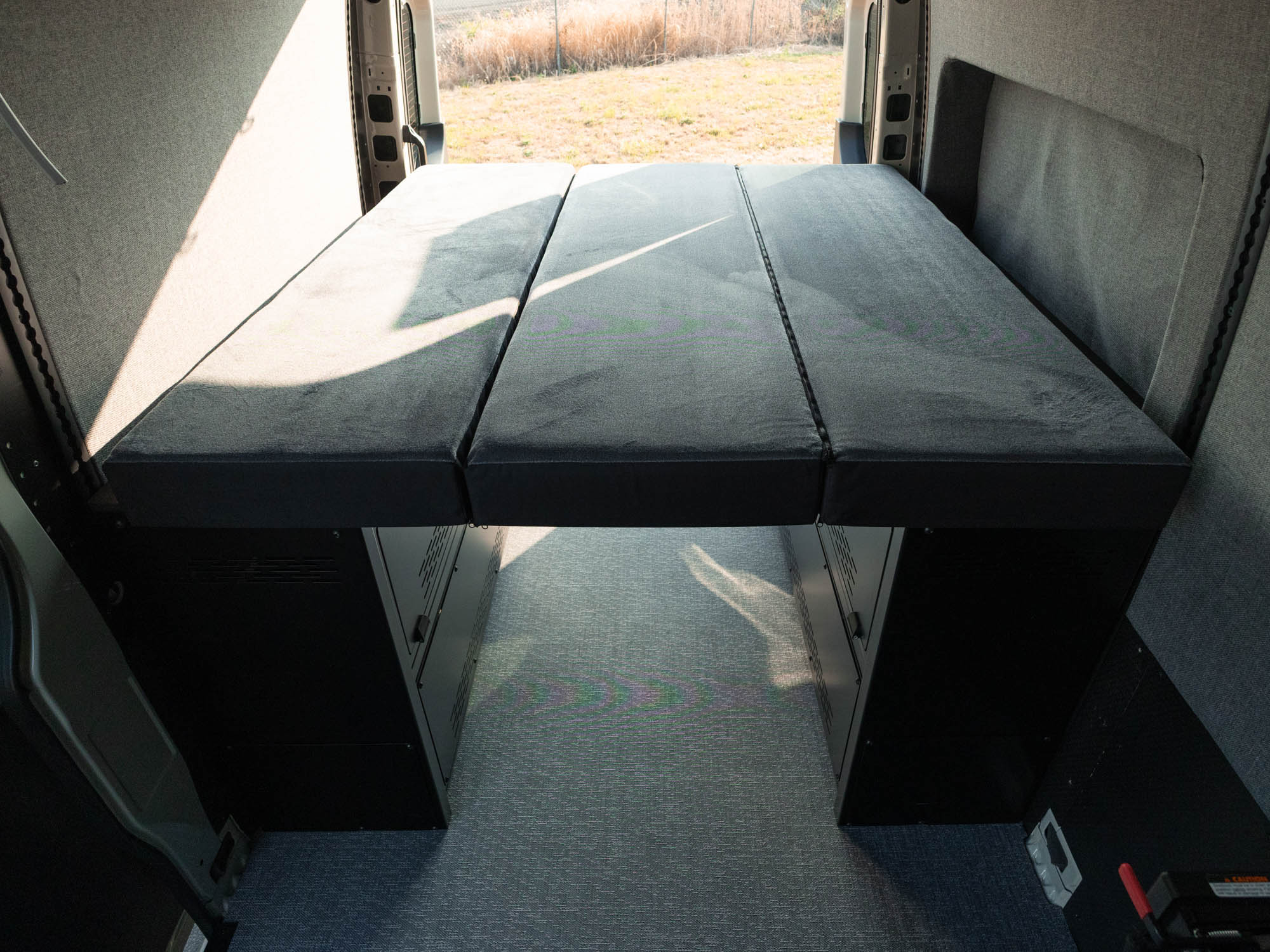 East-West Modular Storage Bed Cabinet System installed in a Sprinter 144 with mattress on top