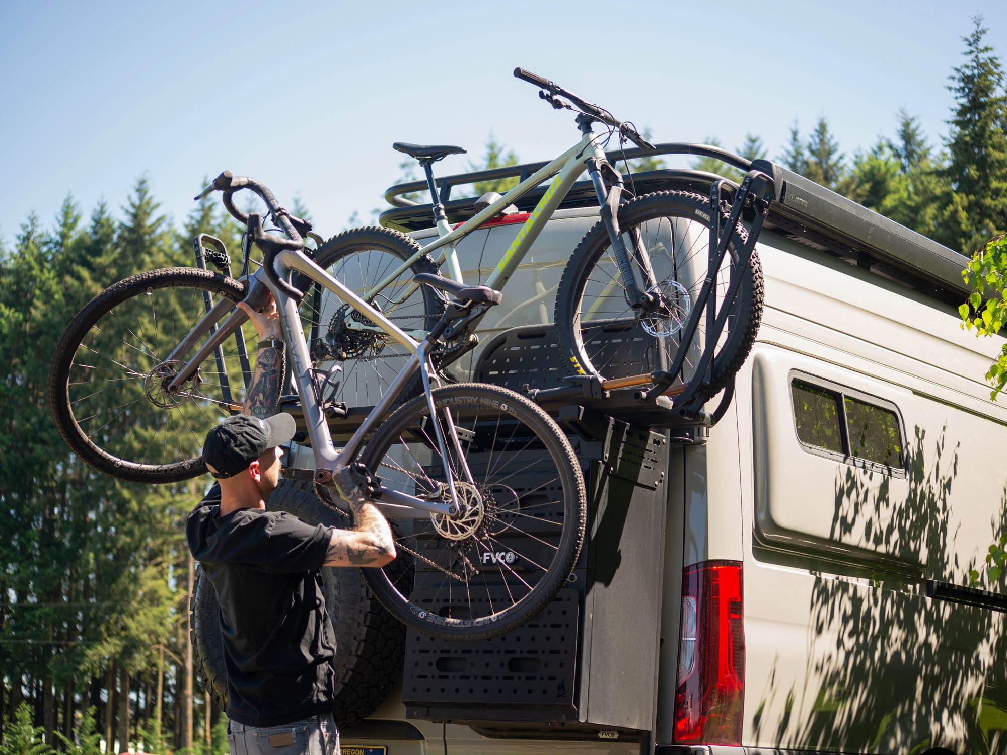 Person loading bikes with Rear Door Storage Box Bike Rack Adapter and Kuat Piston SR Bike trays