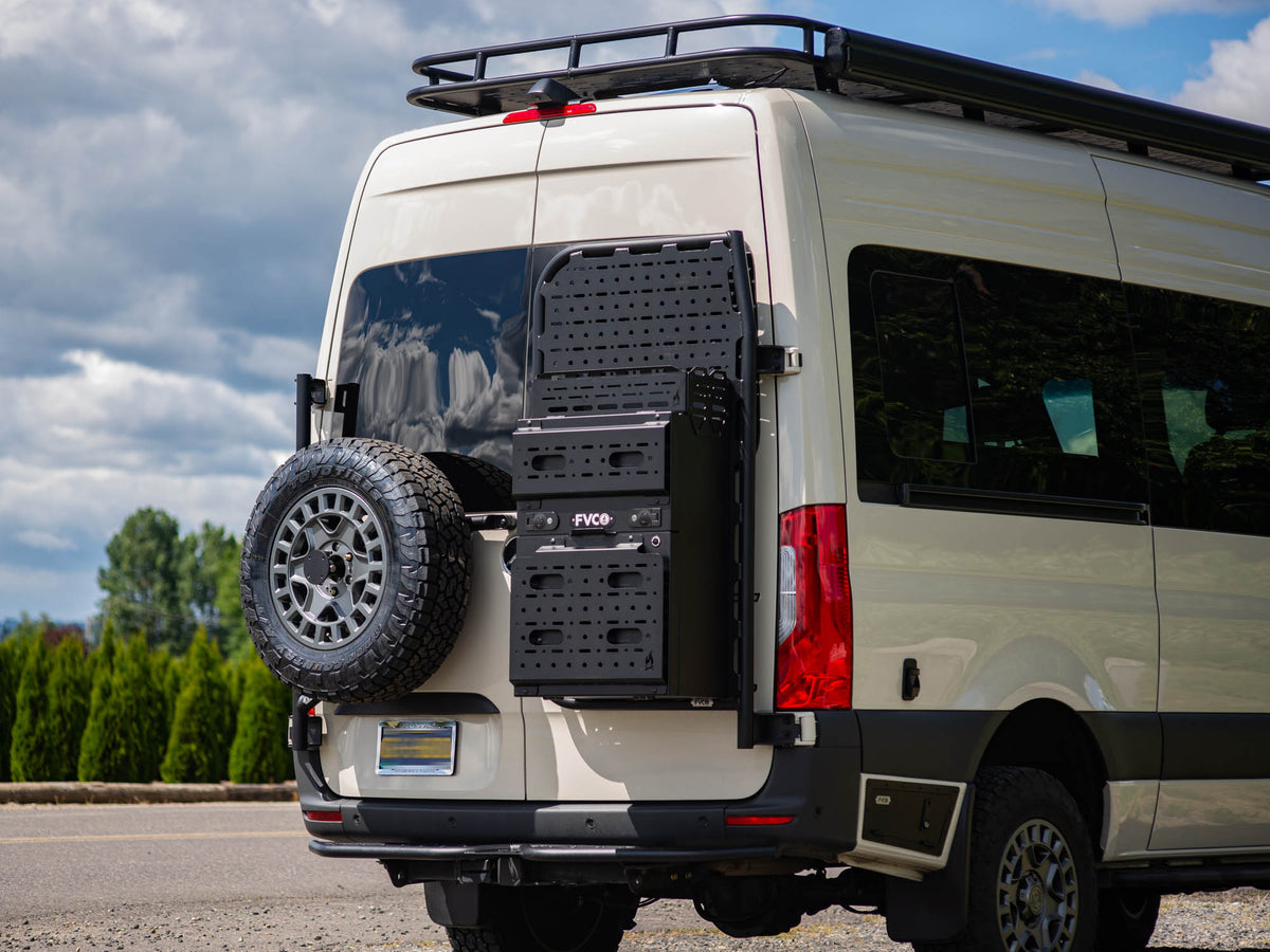 Slim Rear Storage Box Topper installed with the Slim Rear Storage Box on the Sprinter Rear Door Platform. Pictured with installed Sprinter Rear Tire Carrier and Sprinter Rocker Lockers