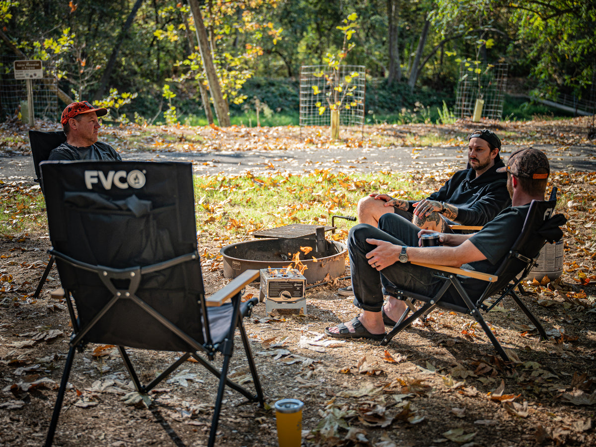 People sitting in FVC Camp Chairs by the fire