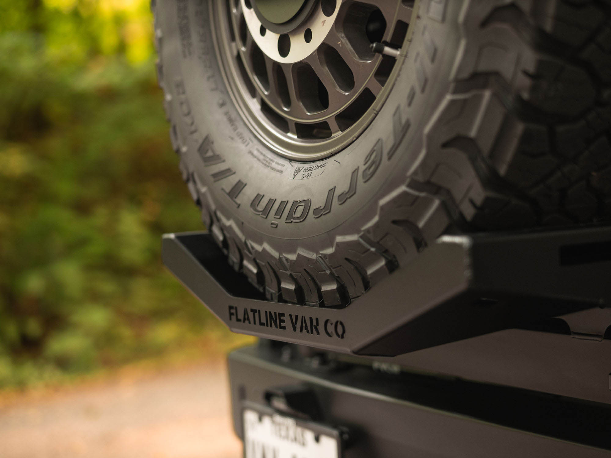 Detail view of Flatline Van Co logo on spare Tire Carrier Mount for Sprinter and Transit Winnebago Ekko coach models