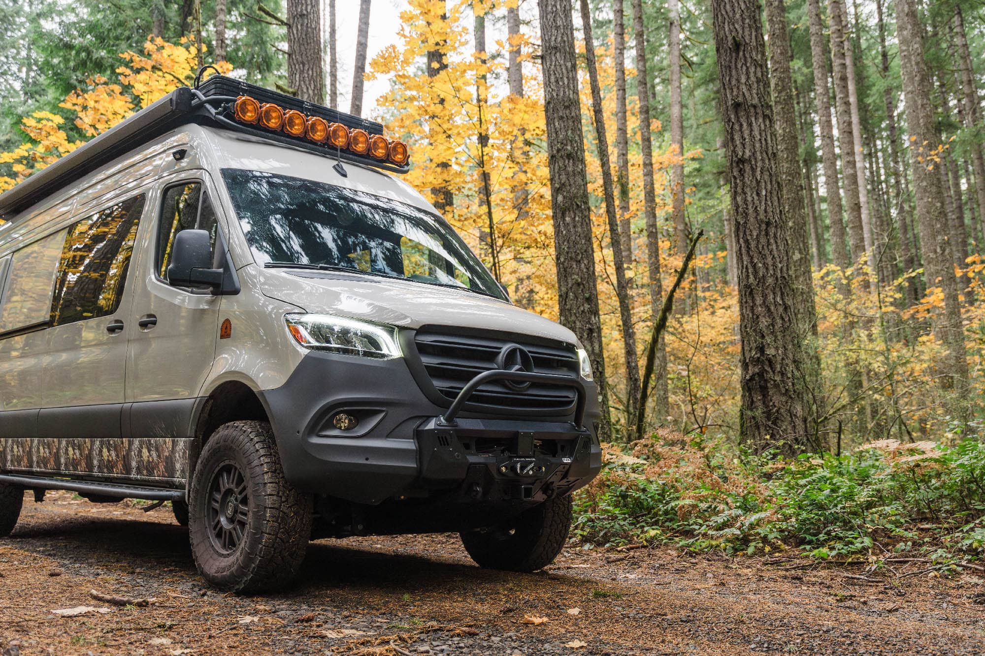 Sprinter Van Core Front Bumper from FVC installed on adventure van driving in the woods
