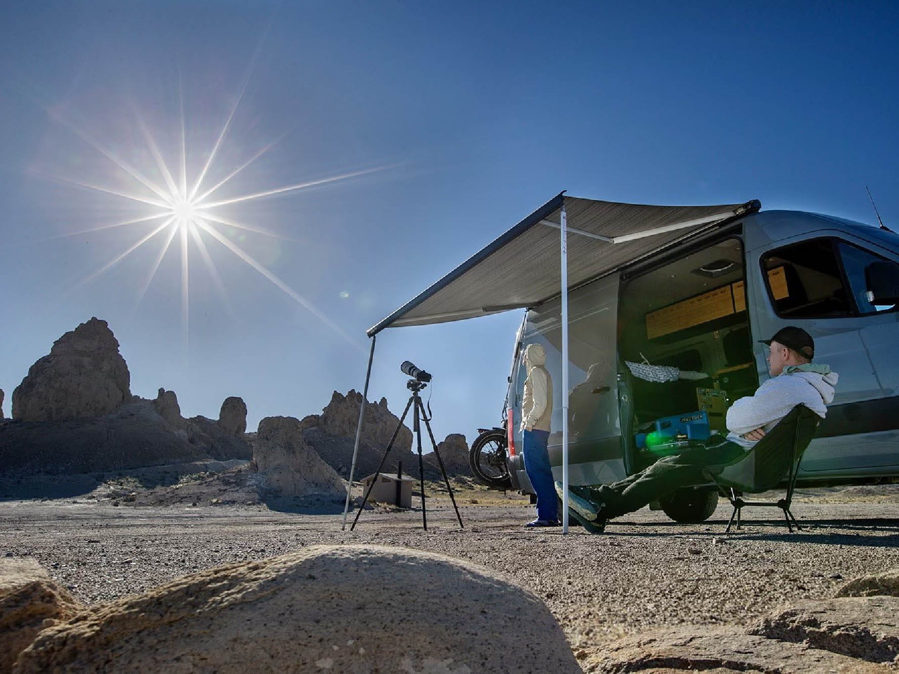 People watching the solar eclipse under shade with their Fiamma F80s awning installed on Sprinter camper van