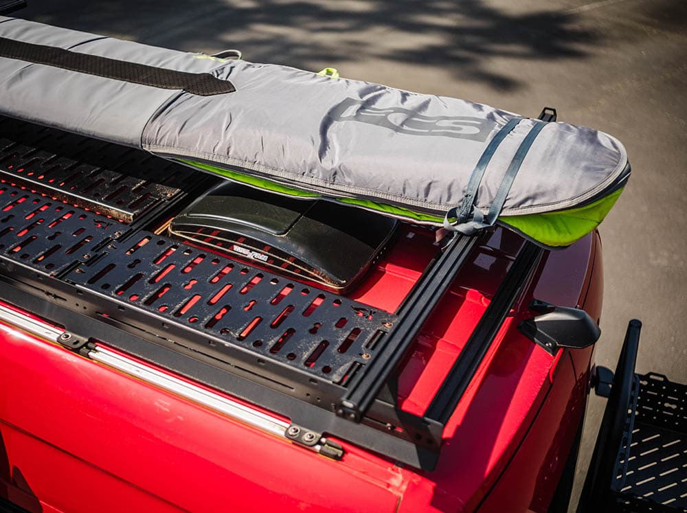 Adventure van using high bar kit to store boards and gear above fans