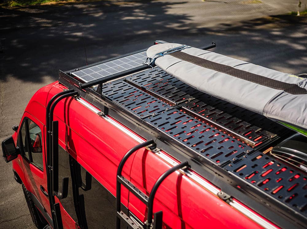 Adventure van with surfboard storage on the roof with high bars