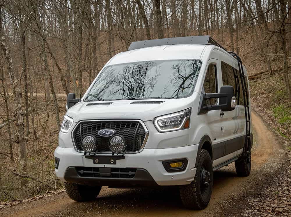 Low-front angle view of Transit Mid Roof Low Pro Roof Rack Installed on white Transit van